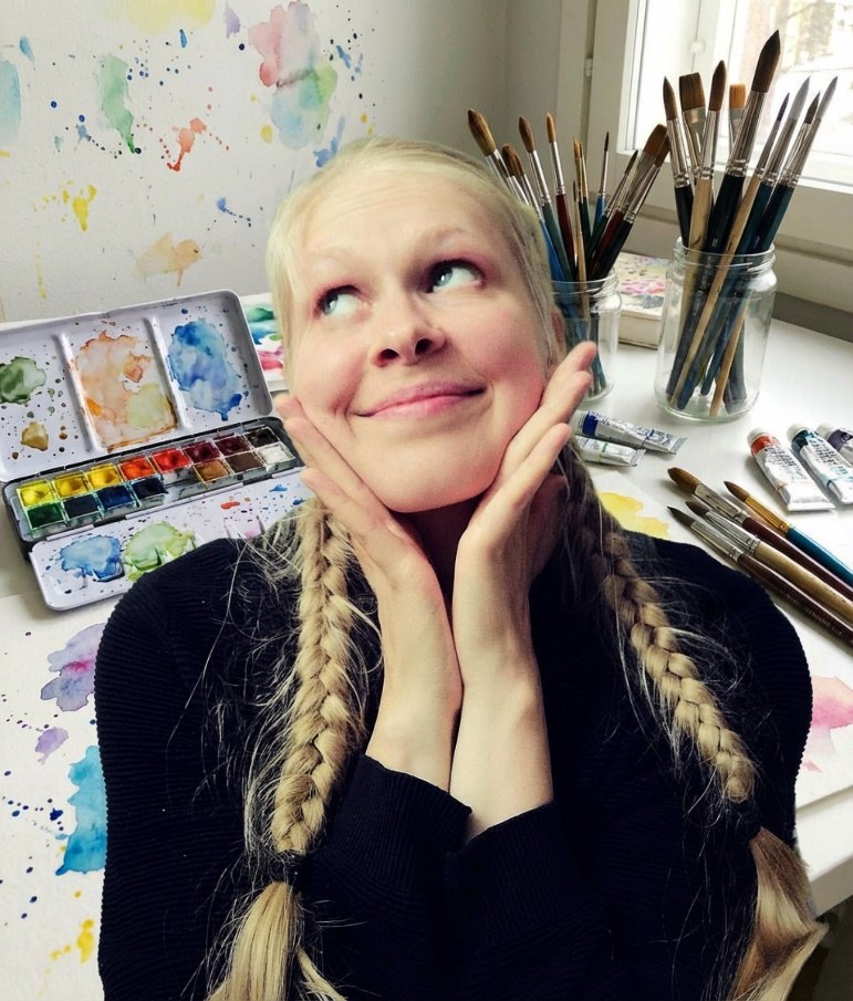 Jasu at her painting table with watercolors and brushes